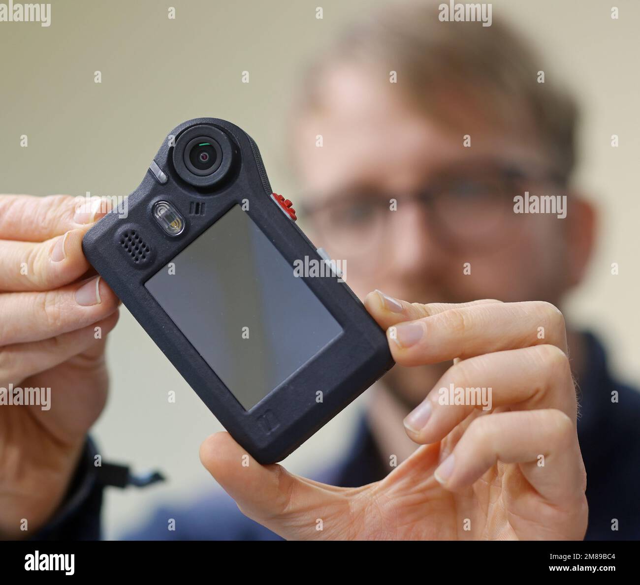 PRODUCTION - 11 January 2023, Saxony-Anhalt, Blankenburg: An employee of the Blankenburg-based company Netco Professional Services GmbH checks a bodycam series. Netco is a specialist in the development, production and sale of these body cameras, which are primarily used by police officers and security forces to document certain deployment scenarios in a way that can be used in court. The devices are used by police officers at soccer clubs, security staff at Deutsche Bahn railroad companies, and public order offices in North Rhine-Westphalia, as well as by the police in Schleswig-Holstein, Bran Stock Photo