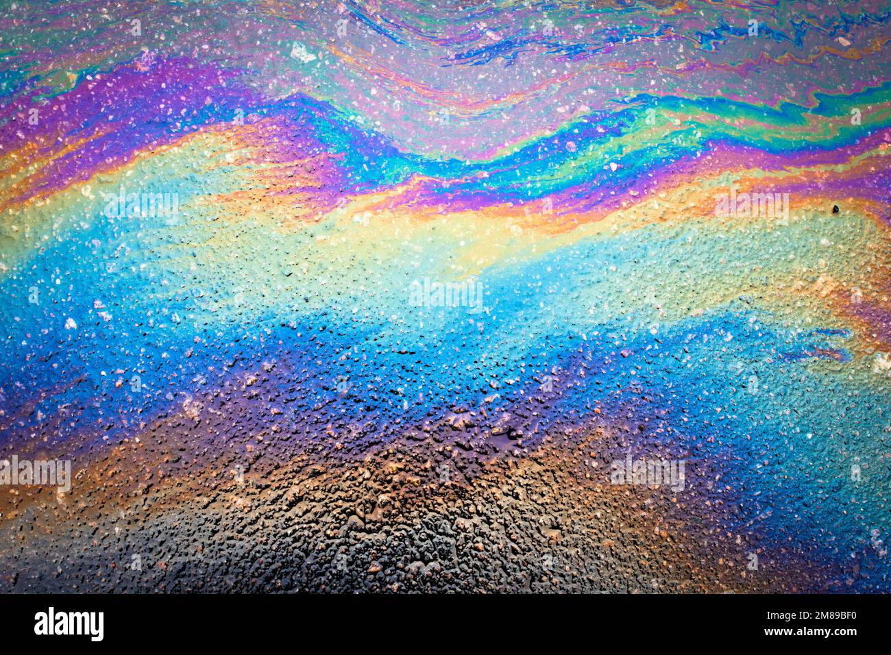 Oil stains from leaks in the car engine. Oil after rain makes spots