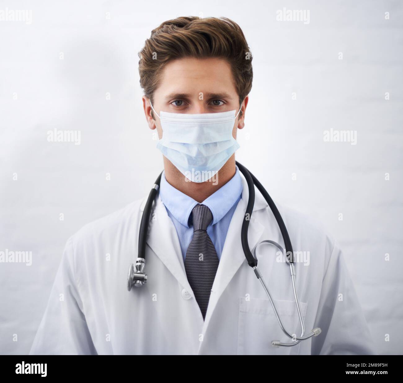 Taking medical matters seriously. Portrait of a serious-looking young doctor wearing a surgical mask. Stock Photo