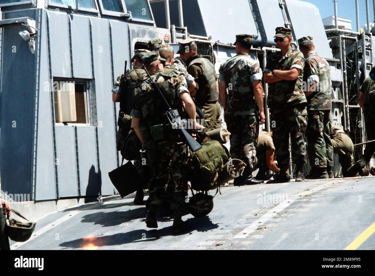 Marines carry their gear up the ramp of an air cushion landing craft