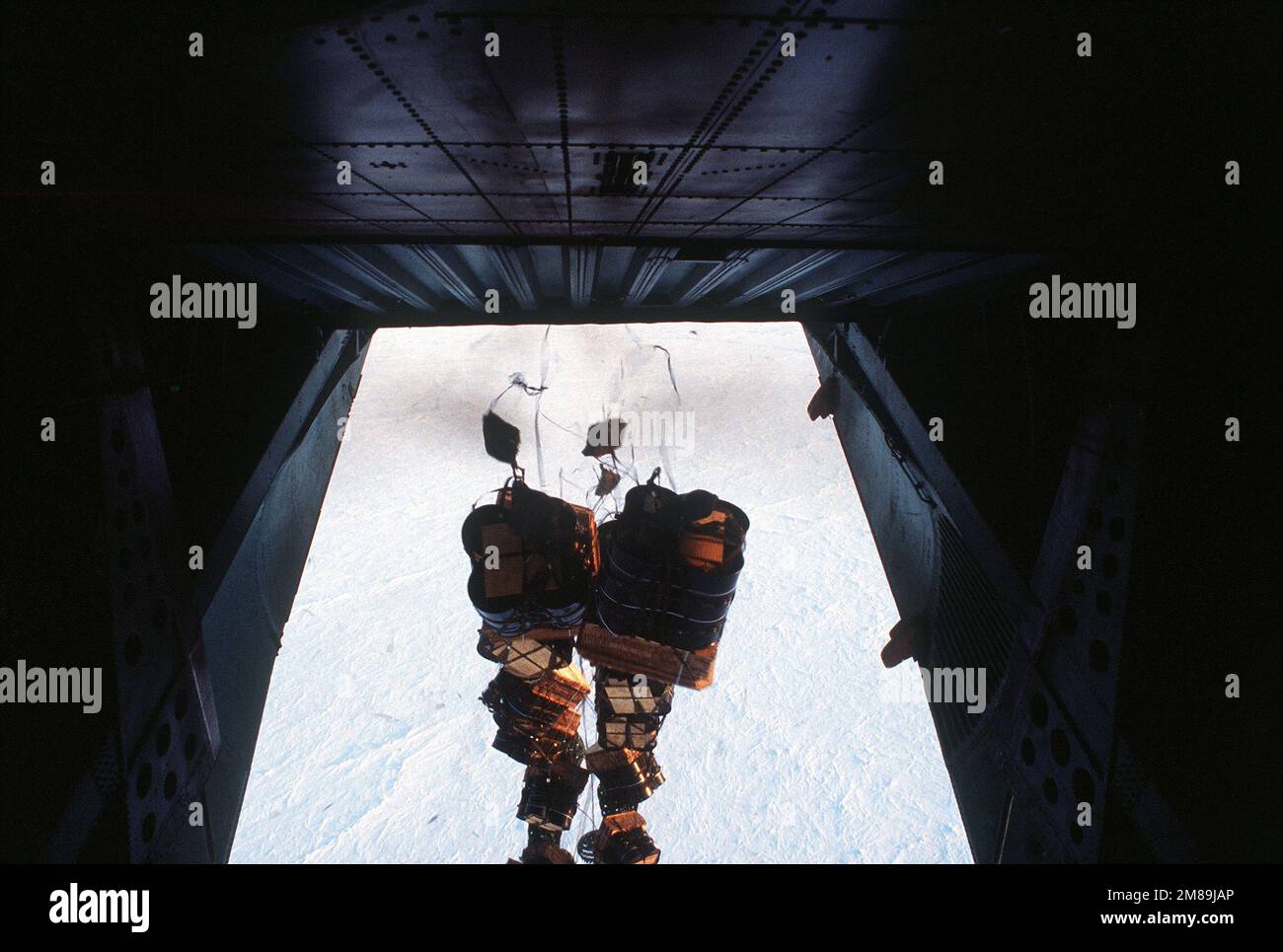 Fuel containers drop from a C-141B Starlifter aircraft during a container delivery system airdrop at Ice Station Zebra, 60 miles from the North Pole. Country: Unknown Stock Photo