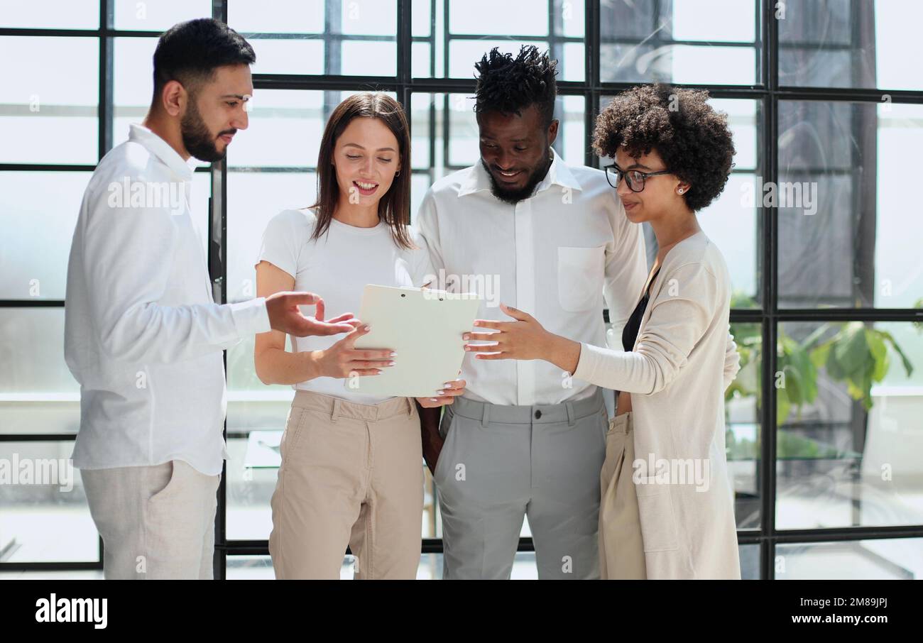 Employees working at computer together, discussing content Stock Photo