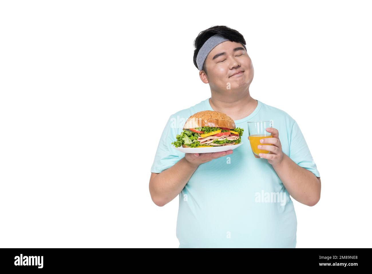 Fat young man holding a hamburger and drinks Stock Photo