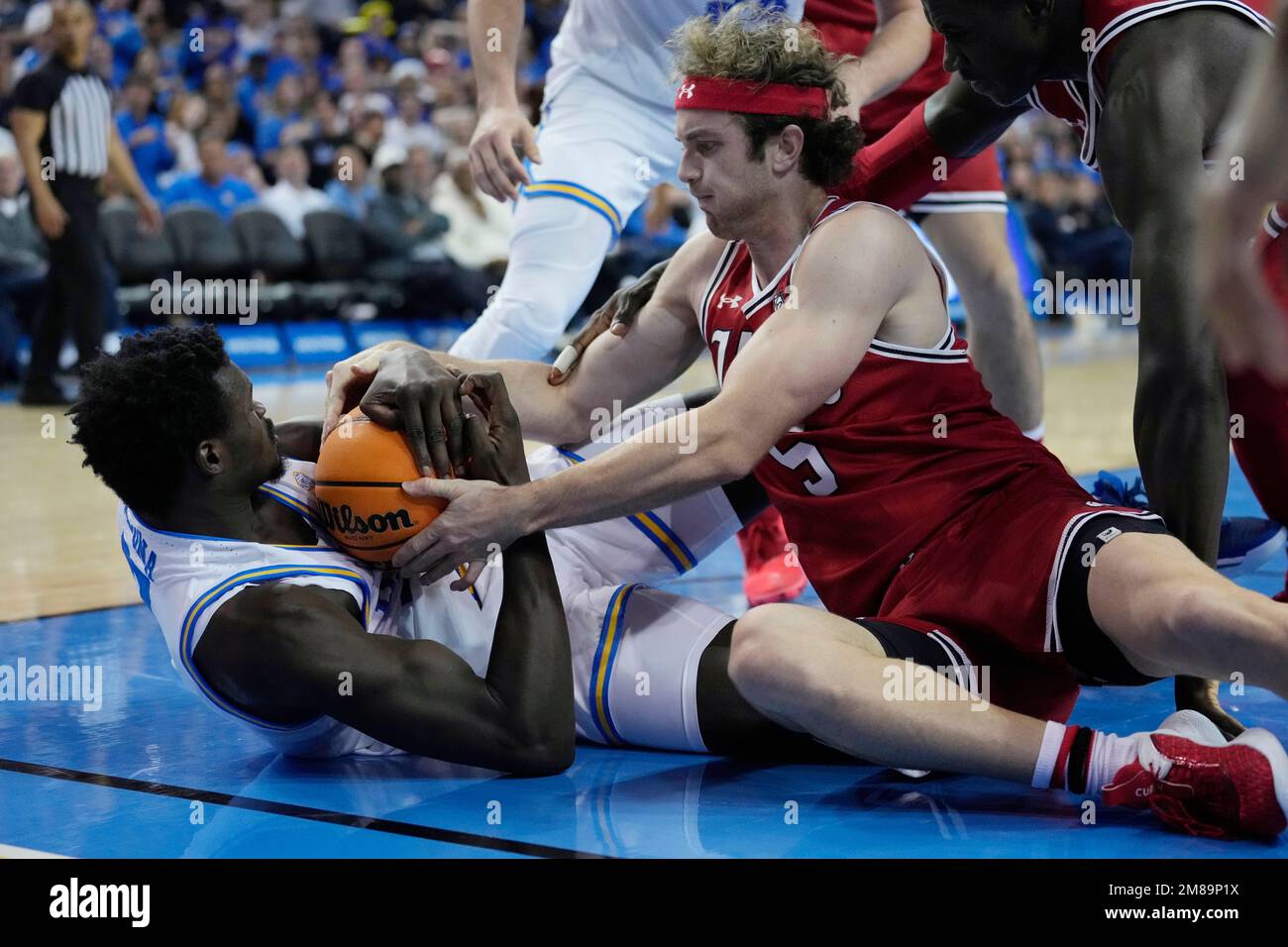 UCLA forward Adem Bona, left, grabs a loose ball next to Utah guard