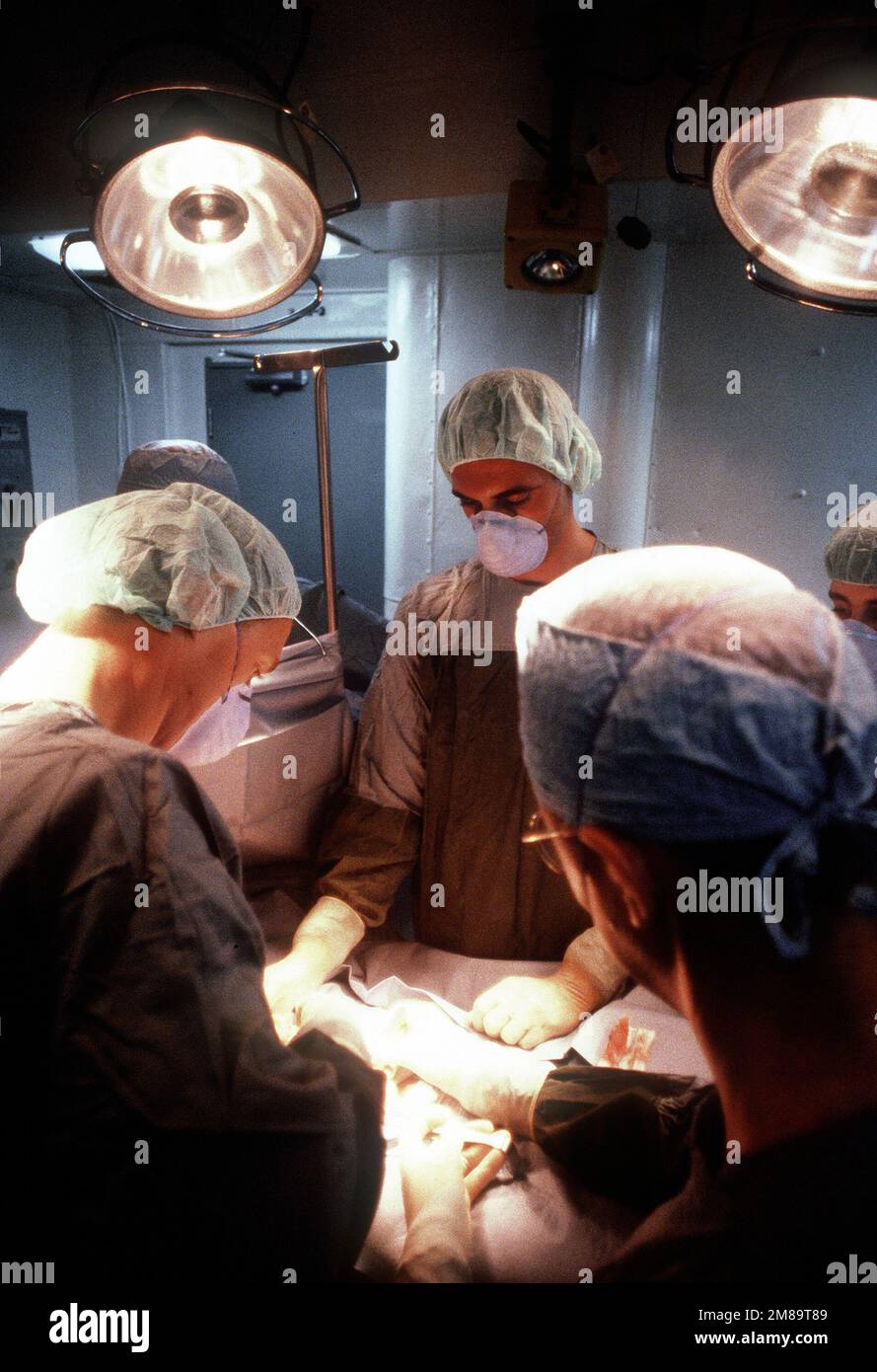 Oral surgeons operate on a patient aboard the battleship USS IOWA (BB