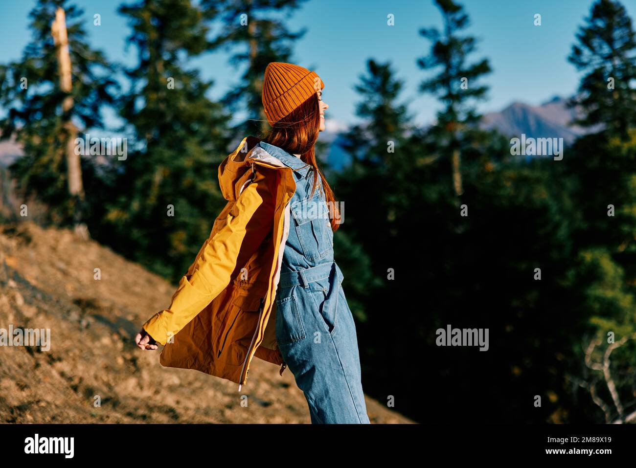 Woman red hair on a hike in the mountains walking a smile and look at ...