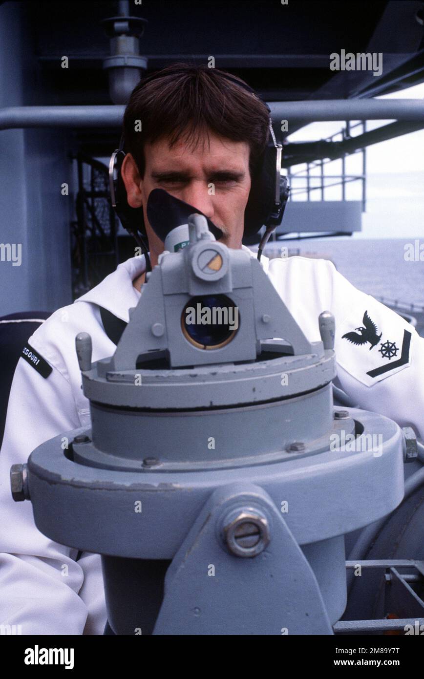 A crew member aboard the battleship USS MISSOURI (BB-63) takes a bearing with a telescopic alidade during Exercise RimPac '88. Subject Operation/Series: RIMPAC '88 Country: Pacific Ocean(POC) Stock Photo