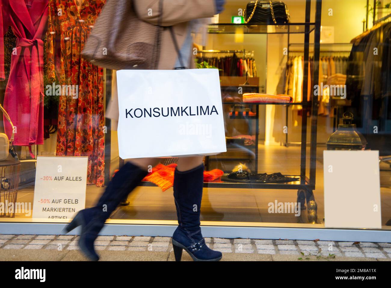Symbolbild Konsum: Frau beim Einkaufen, auf der Einkaufstüte steht  Konsumklima (Composing, Model released) Stock Photo
