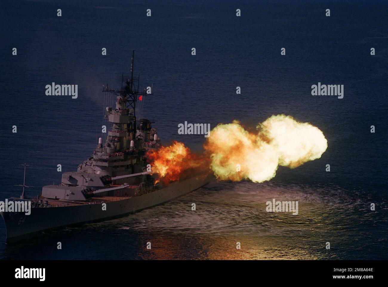 A port bow view of the battleship WISCONSIN (BB64) firing its Mark 7 16inch/50caliber guns
