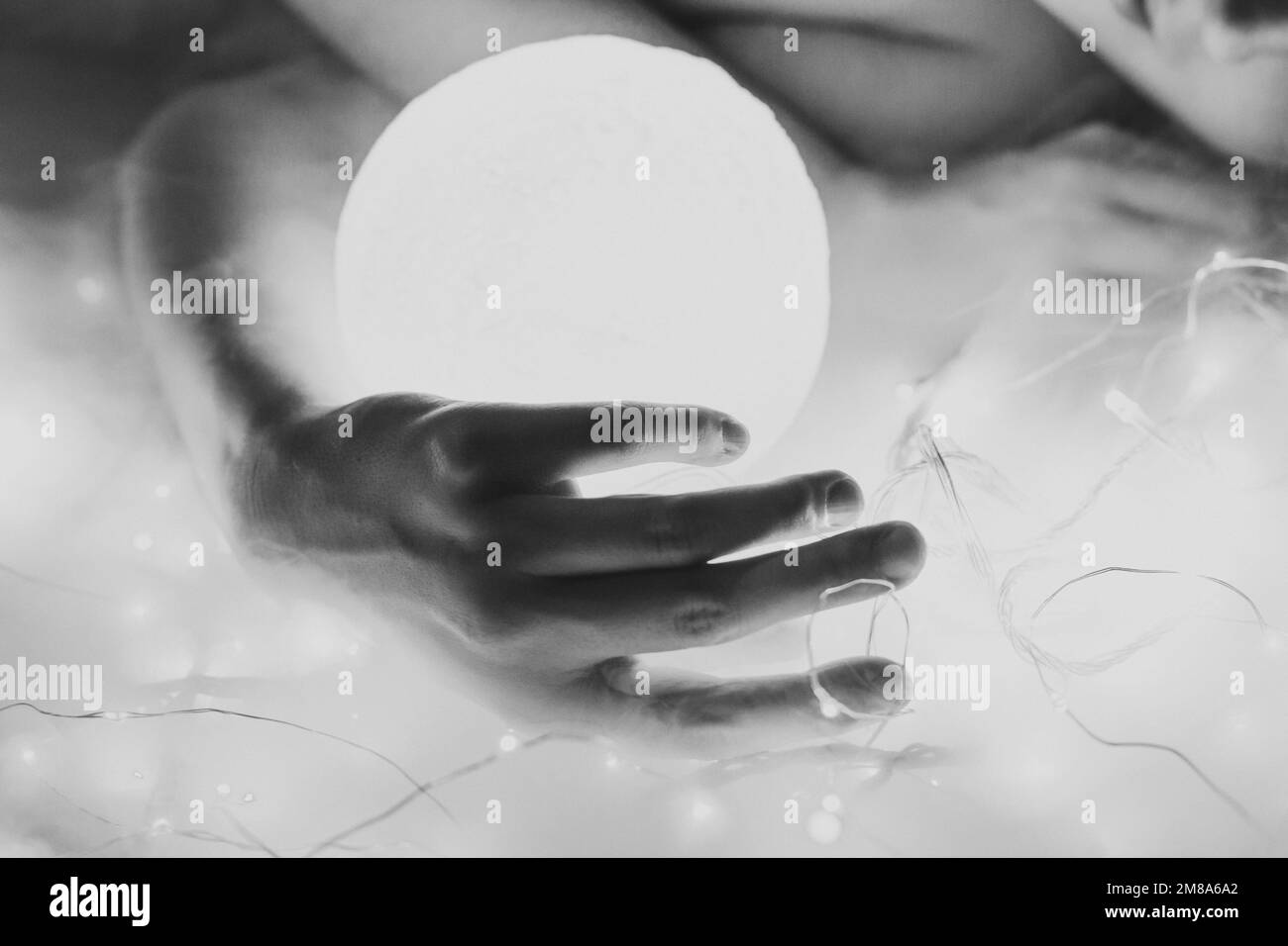 Close up woman with glowing neon ball monochrome concept photo Stock Photo