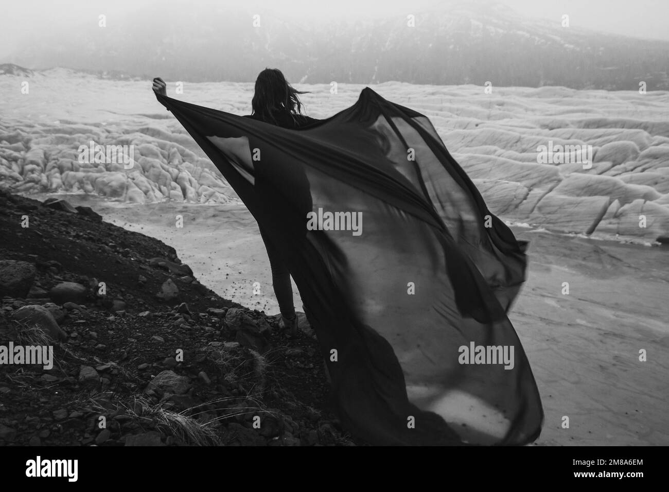 Graceful lady with waving fabric sheet monochrome scenic photography Stock Photo