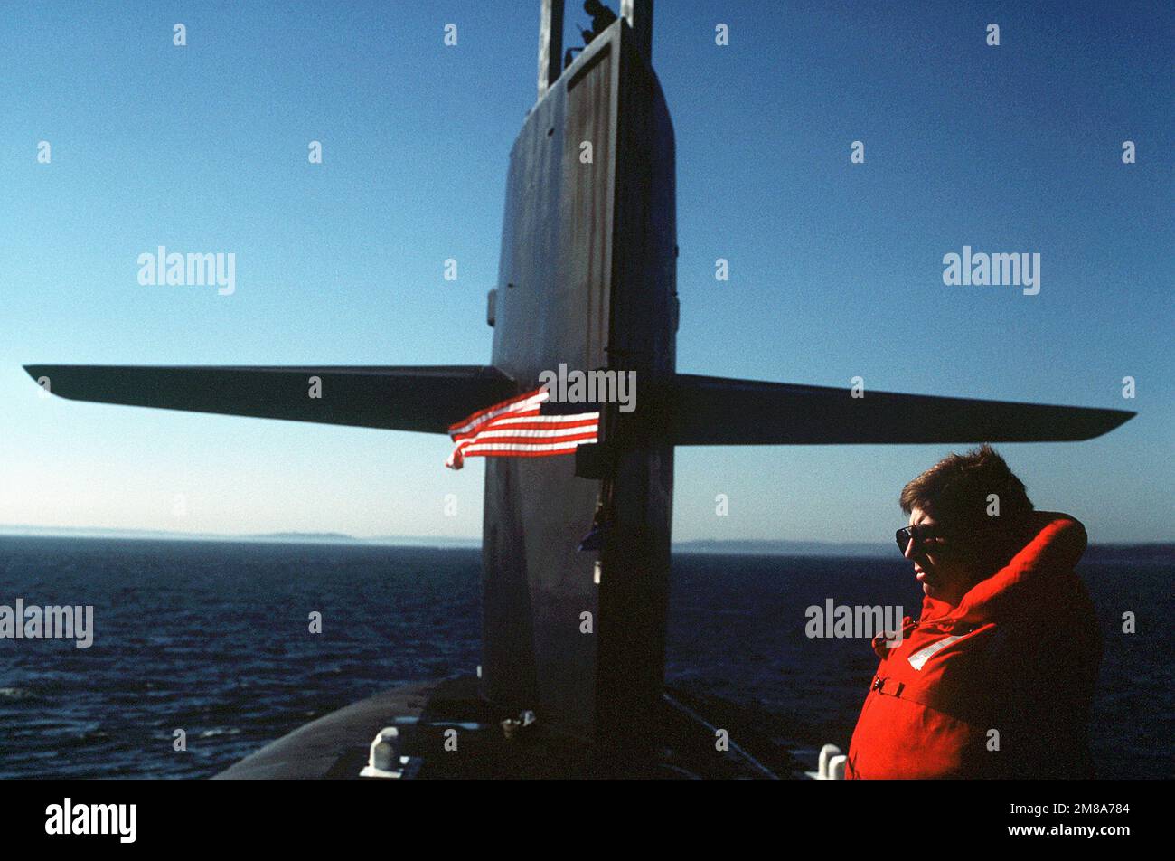 A crewman stands at the sail on the nuclear-powered strategic missile submarine USS ALABAMA (SSBN-731) as the vessel returns to port after completing the 100th Trident ballistic missile submarine patrol. Base: Naval Submarine Base, Bangor State: Washington (WA) Country: United States Of America (USA) Stock Photo