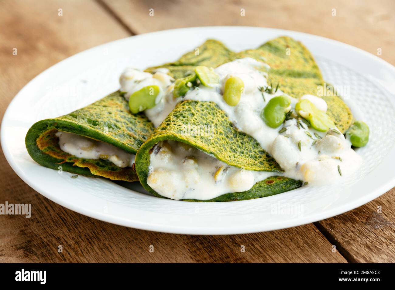 Green Pancakes with creamy fava beans. Stock Photo