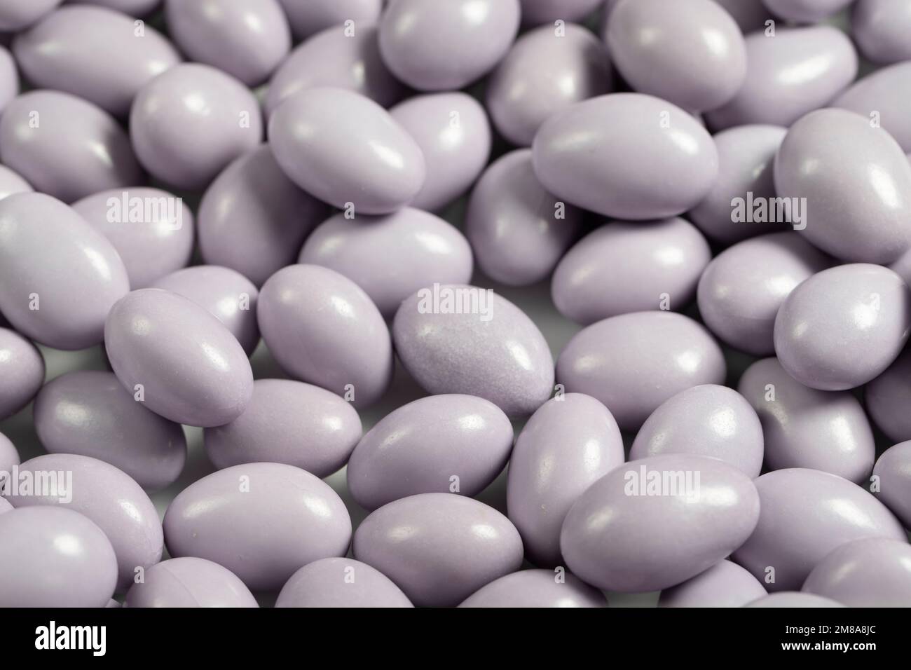 Chocolate dragee in the form of a pile. White chocolate dragee covered with sugar on the outside and filled with chocolate on the inside. close up Stock Photo