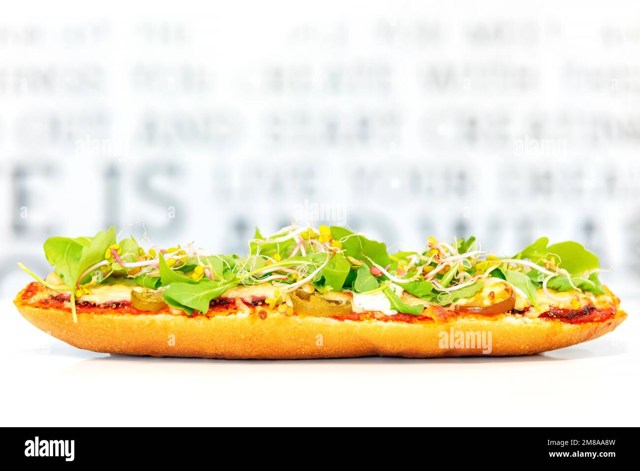baguette with tomato sauce, meat, jalapeno and arugula baked with cheese. fast and popular street food Stock Photo