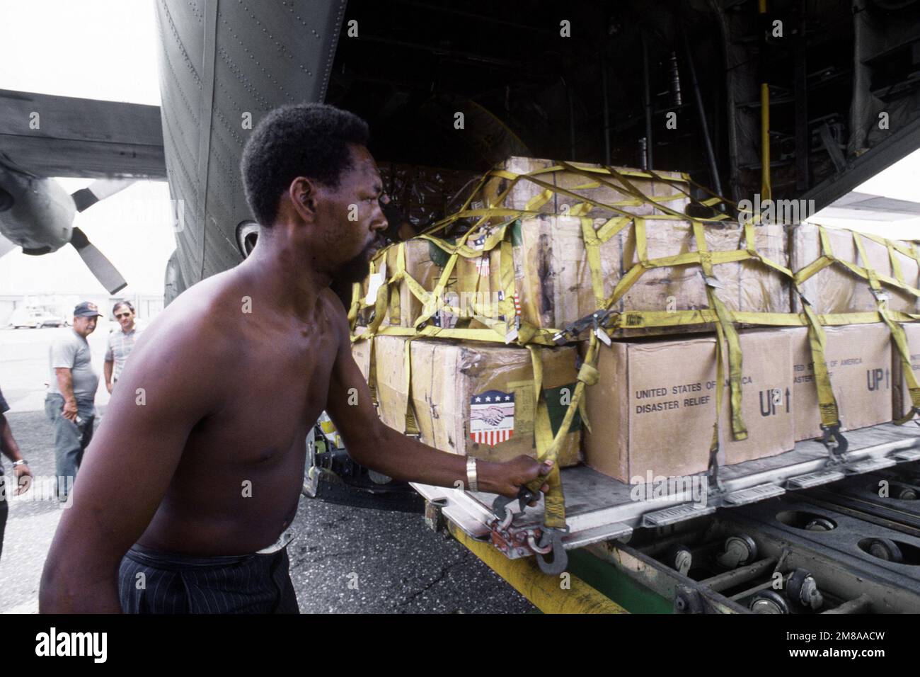 A Jamaican helps offload disaster relief supplies from a C130 Hercules