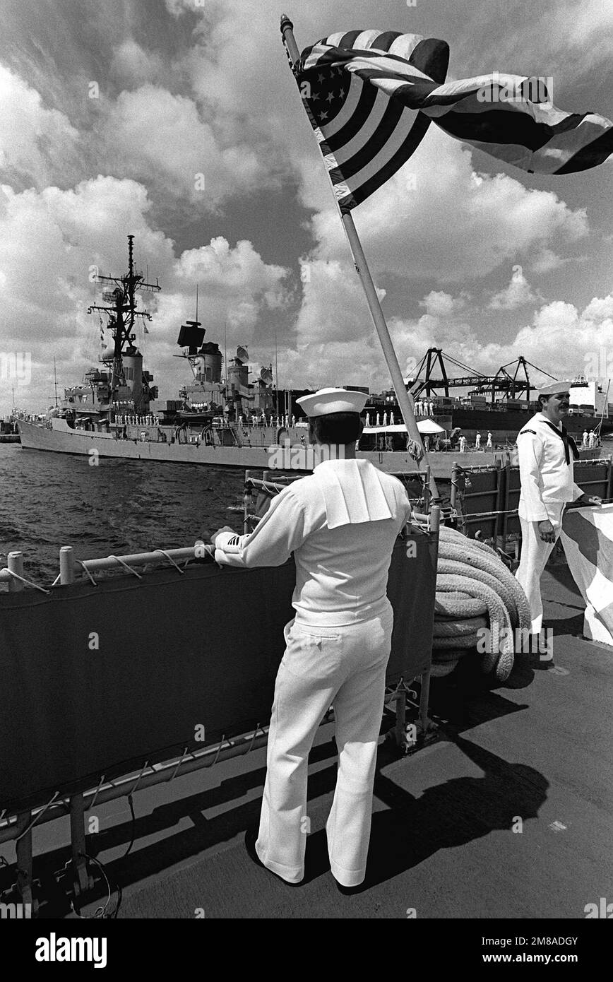 Fire Control Technician 1ST Class David Mehan stands on the stern of the guided missile cruiser USS SAN JACINTO (CG-56) to watch the arrival of the guided missile destroyer USS TATTNALL (DDG-19) at the beginning of Navy Appreciation Week, which is being sponsored by the local Navy League chapter. Base: Port Everglades State: Florida (FL) Country: United States Of America (USA) Stock Photo