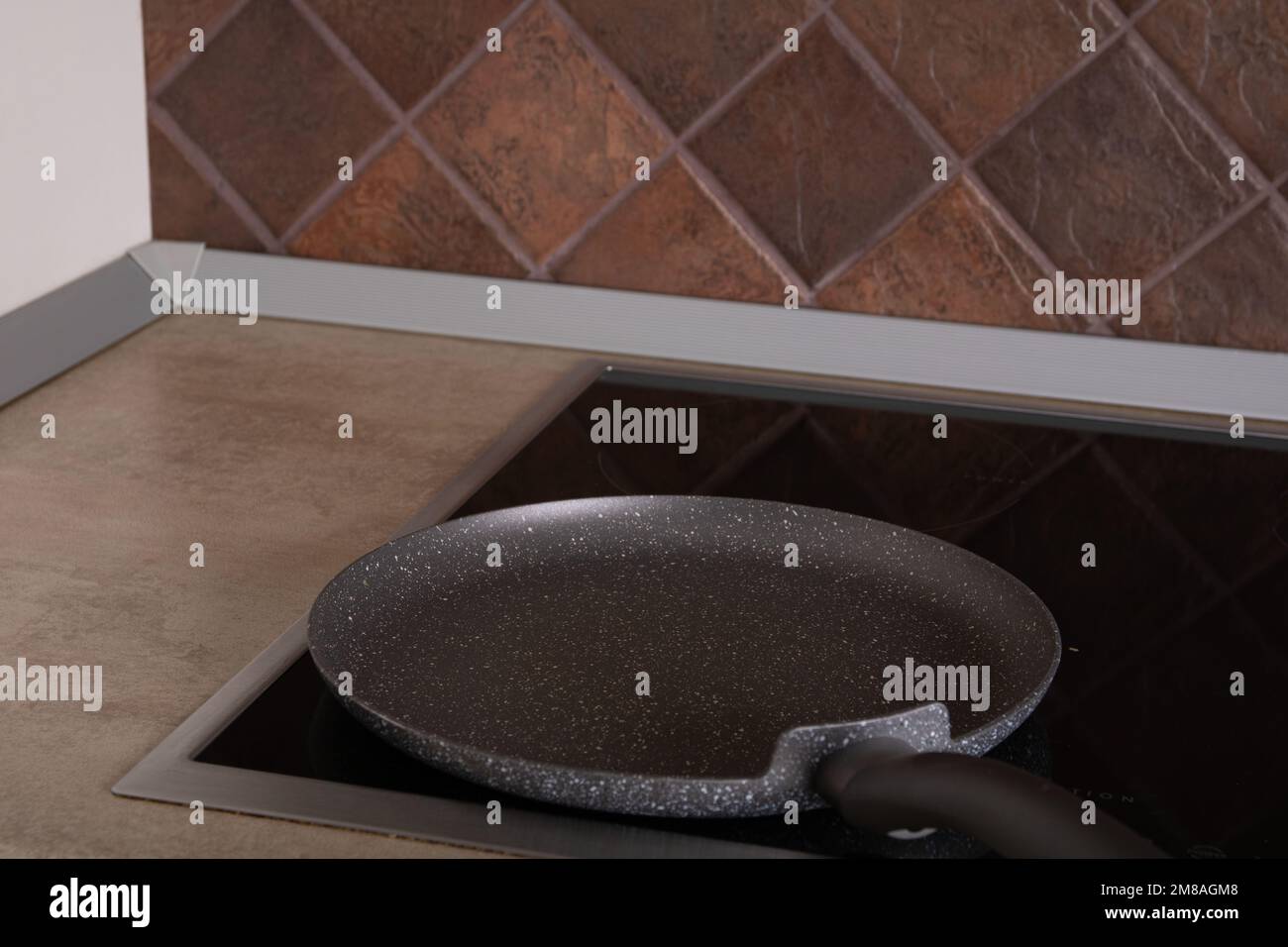 photo of an empty frying pan standing on an empty stove in the kitchen Stock Photo