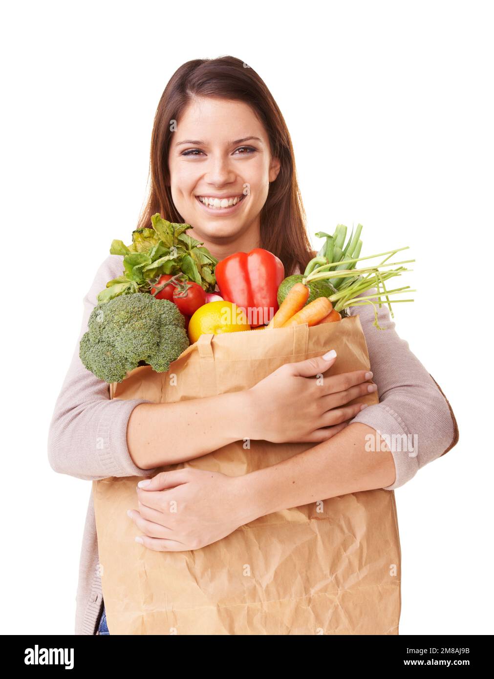She loves shopping for vegetables. Portrait of an attractive young woman holding a bag of groceries. Stock Photo