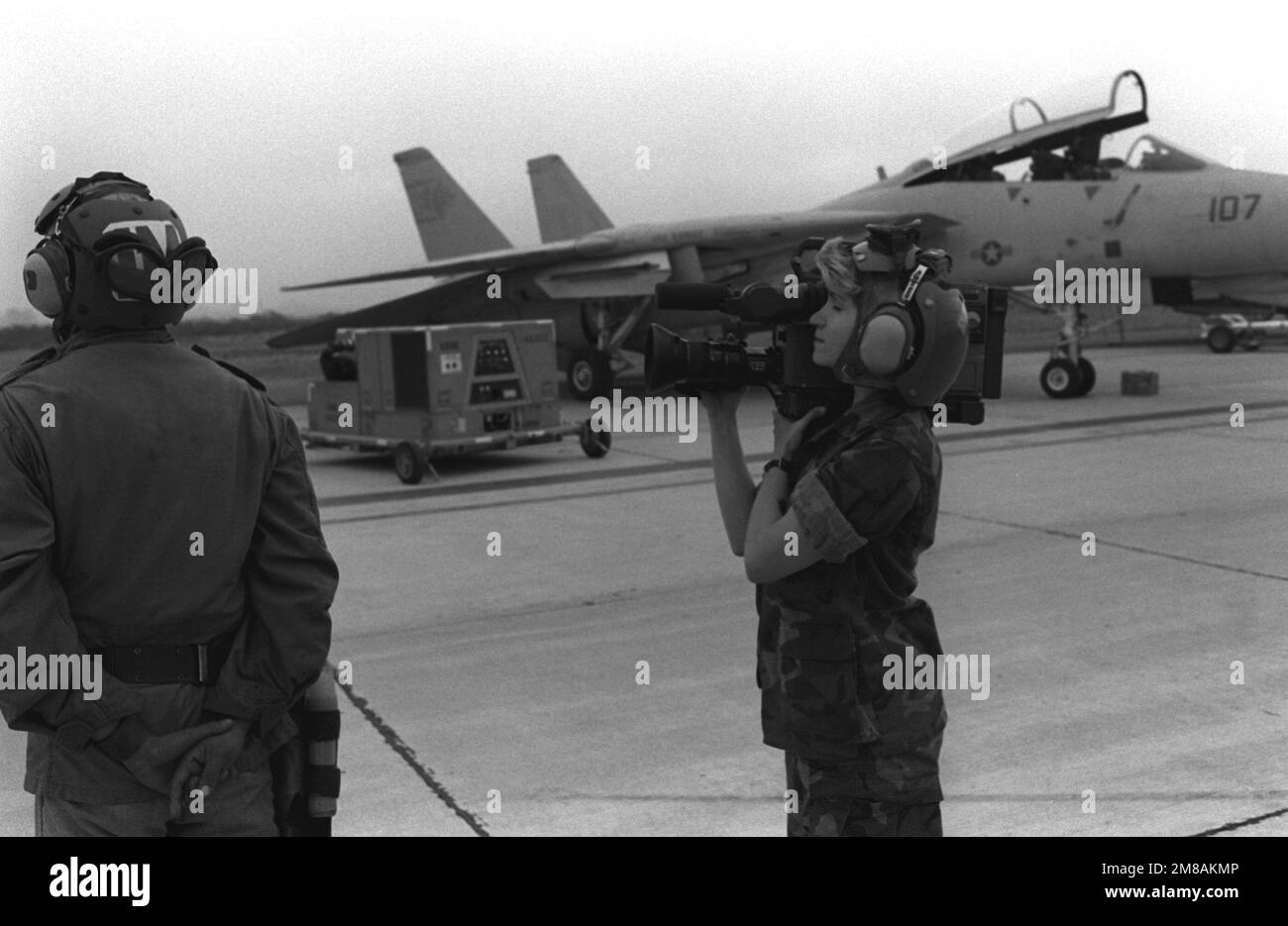 A photographer's mate videotapes flight operations of Fighter Squadron