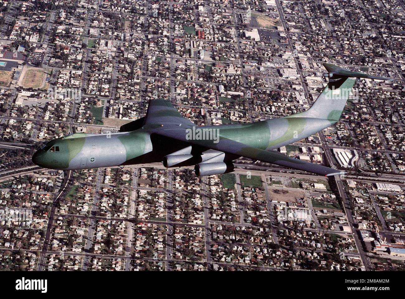 An air-to-air left side view of a C-141B Starlifter aircraft in flight ...