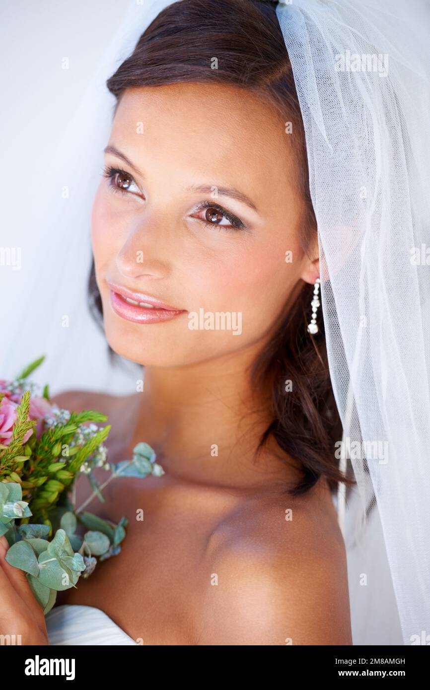 The best day of her life. A gorgeous young bride holding her bouquet. Stock Photo