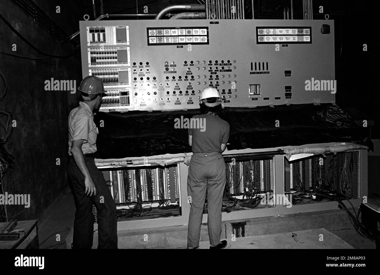 Technicians install a main control board in the Trident submarine refit