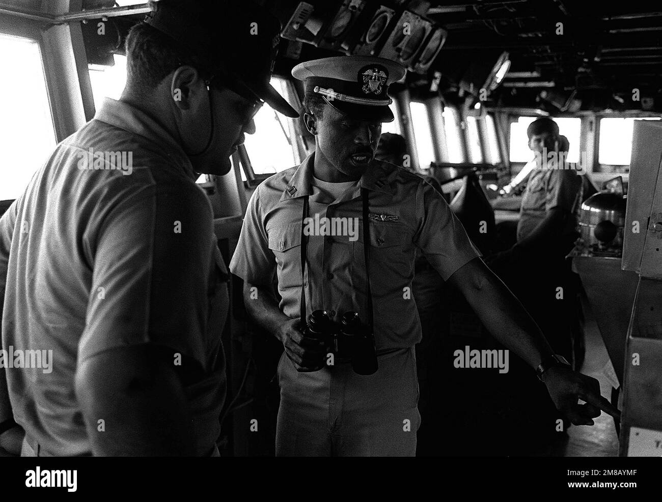 An officer makes a point to a crewman on the bridge of the tank landing