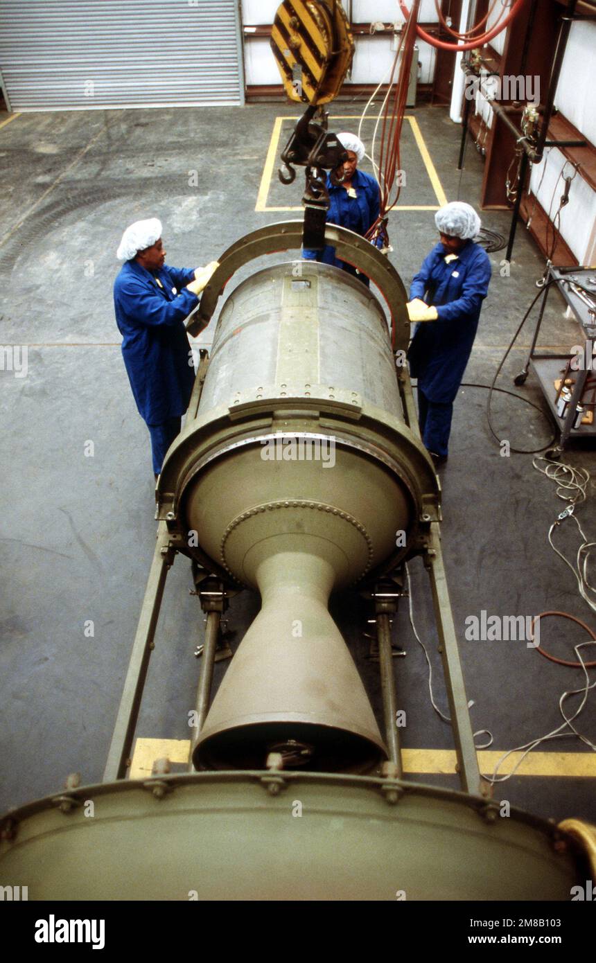 Three plant employees attach a lifting collar to a propulsion stage of a Pershing 1A missile in Building 44-T. Several missiles are being destroyed in the presence of Soviet inspectors in accordance with the Intermediate-Range Nuclear Forces (INF) Treaty. Base: Longhorn Army Ammunition Plant State: Texas (TX) Country: United States Of America (USA) Stock Photo