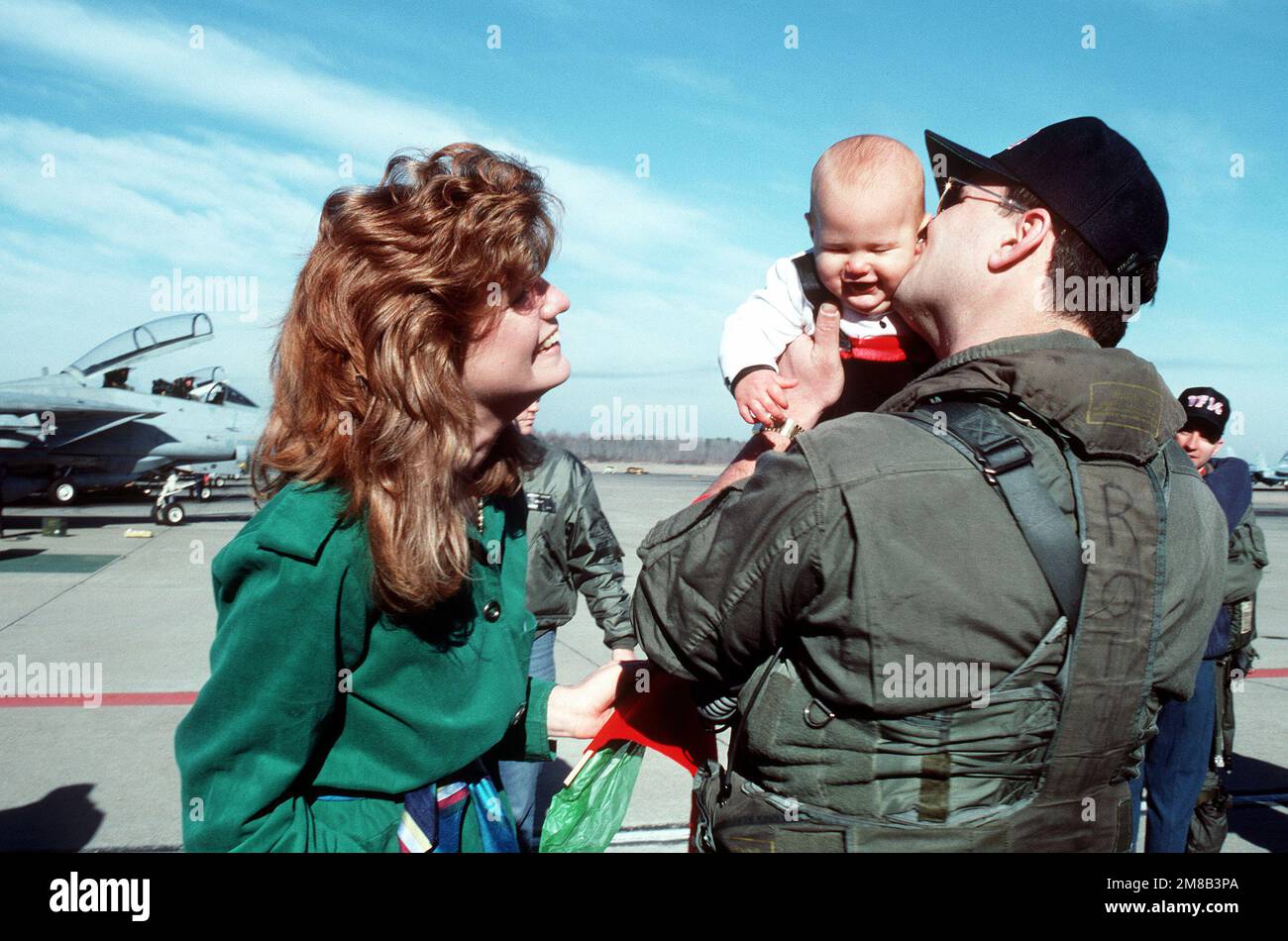 A Fighter Squadron 32 (VF-32) aviator is reunited with his family upon the squadron's return to home port after a deployment aboard the aircraft carrier USS JOHN F. KENNEDY (CV-67). Base: Naval Air Station, Oceana State: Virginia (VA) Country: United States Of America (USA) Stock Photo
