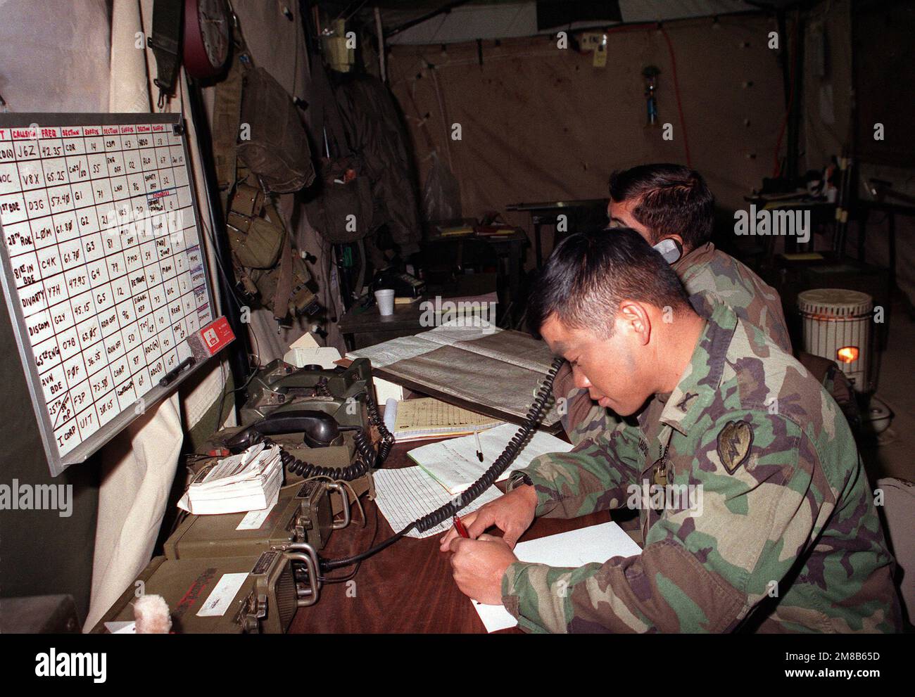 LTC Ted W. Hashimoto, Commanding Officer, Military Police Battalion, 25th  Infantry Division (Light) works in his battalion's tactical operations  center during the joint South Korean/U.S. exercise Team Spirit '89. The  soldiers are