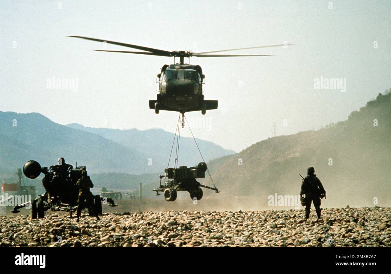 A UH-60 Black Hawk helicopter brings in an M-167 towed Vulcan Air Defense System (ADS) as the crew of a second ADS prepares their weapon for action during the joint South Korean/United States exercise TEAM SPIRIT '89. Subject Operation/Series: TEAM SPIRIT '89 Country: Republic Of Korea (KOR) Stock Photo