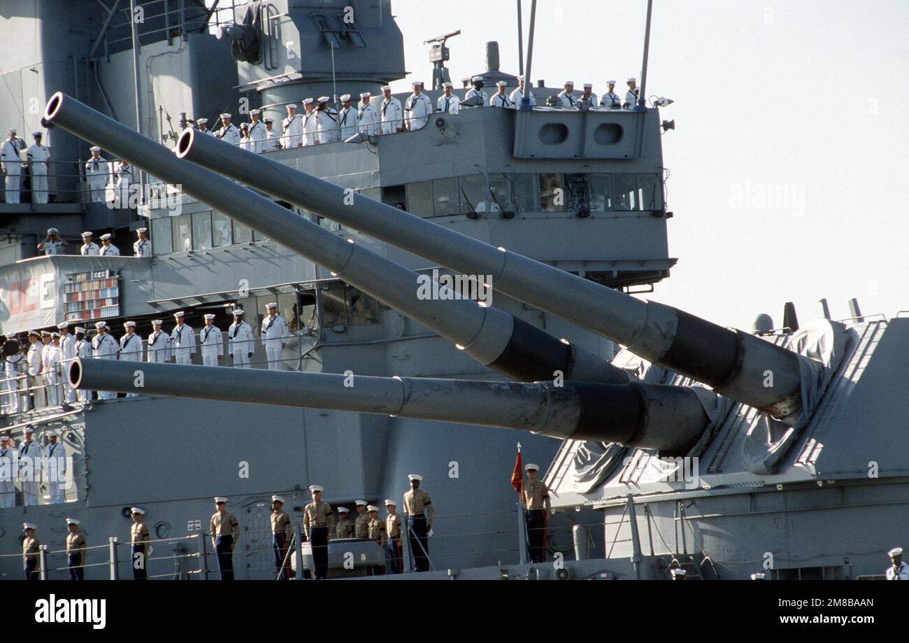 Sailors line the rails, and Marines stand at attention beneath the No ...
