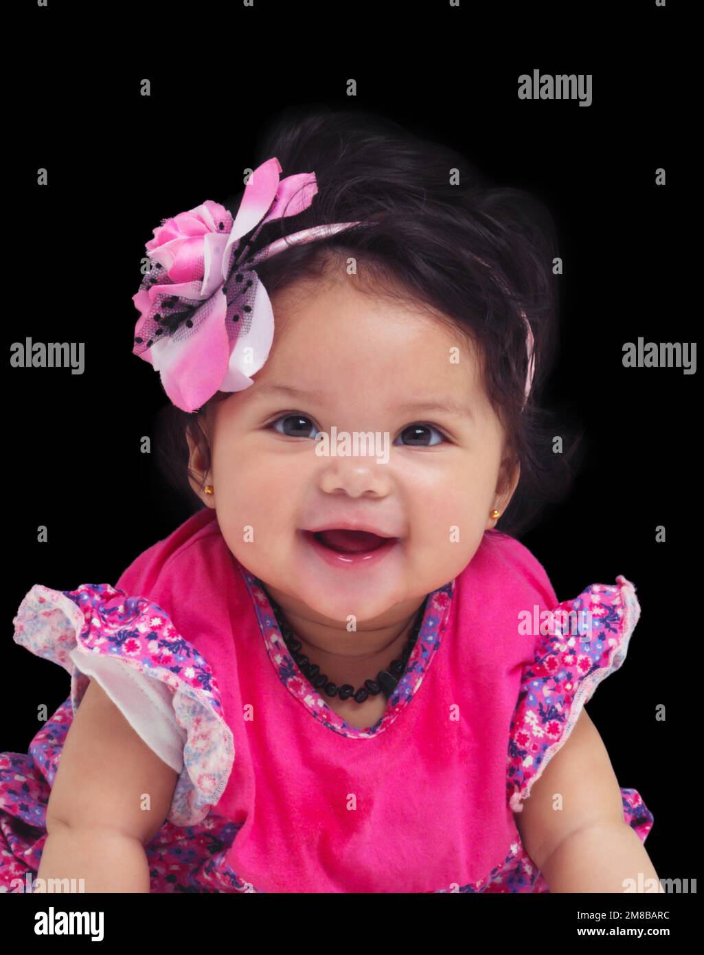 Portrait, baby and girl with a newborn infant in studio on a black background in floral clothes. Kids, flower and development with a female child on Stock Photo