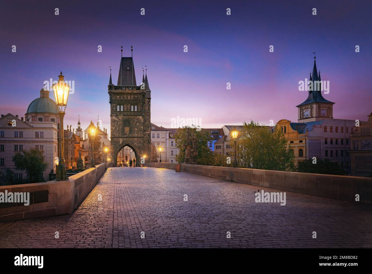 Illuminated Charles Bridge view at sunrise with Old Town Bridge Tower - Prague, Czech Republic Stock Photo
