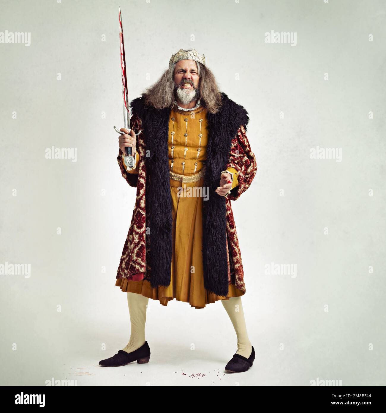 King, portrait and man with bloody sword in studio isolated on a gray