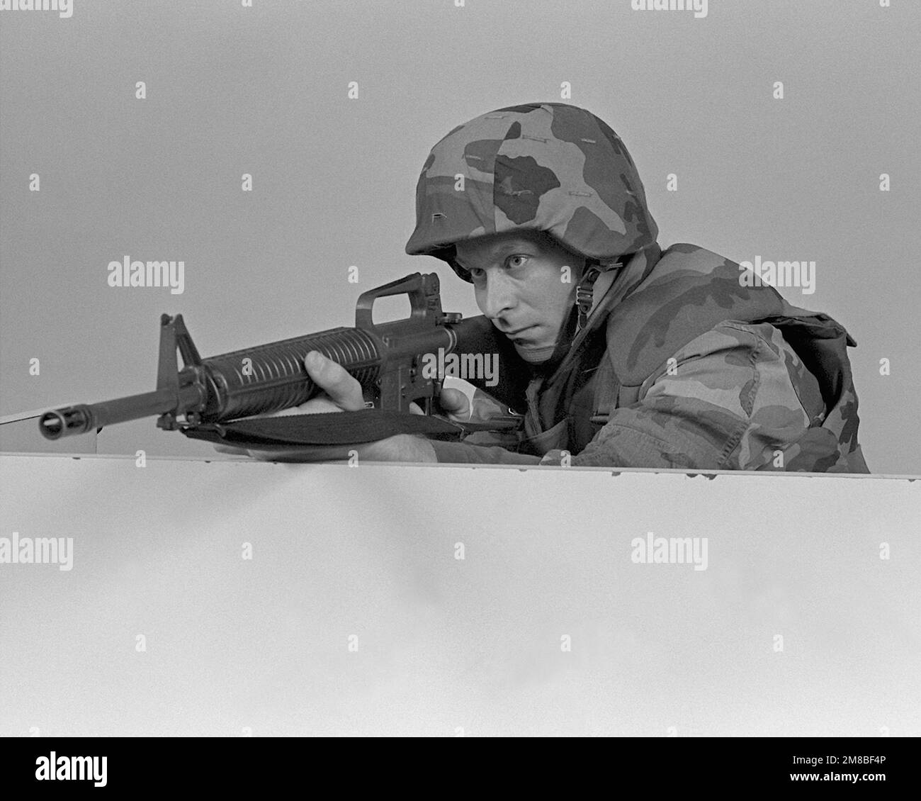 A Marine demonstrates how to use a barricade for cover when firing. He ...