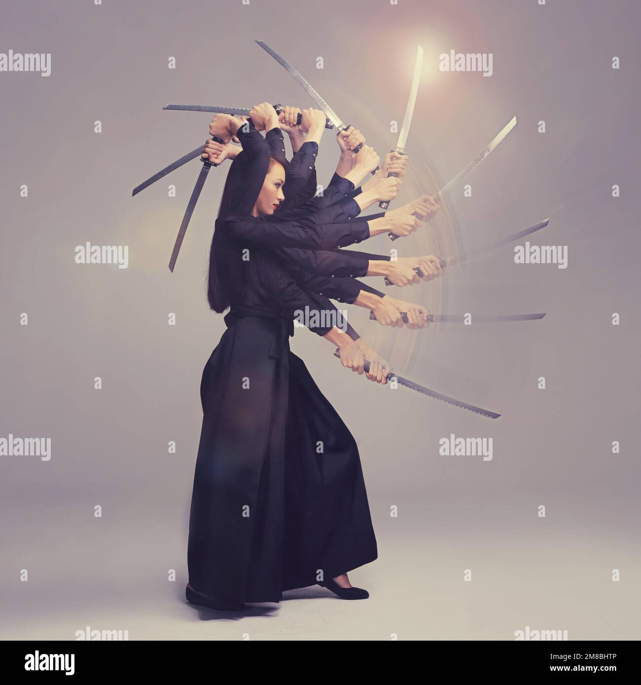 Woman, warrior nun and sword in martial arts with motion blur strike against a studio background. Female wielding a sharp samurai blade, weapon or Stock Photo