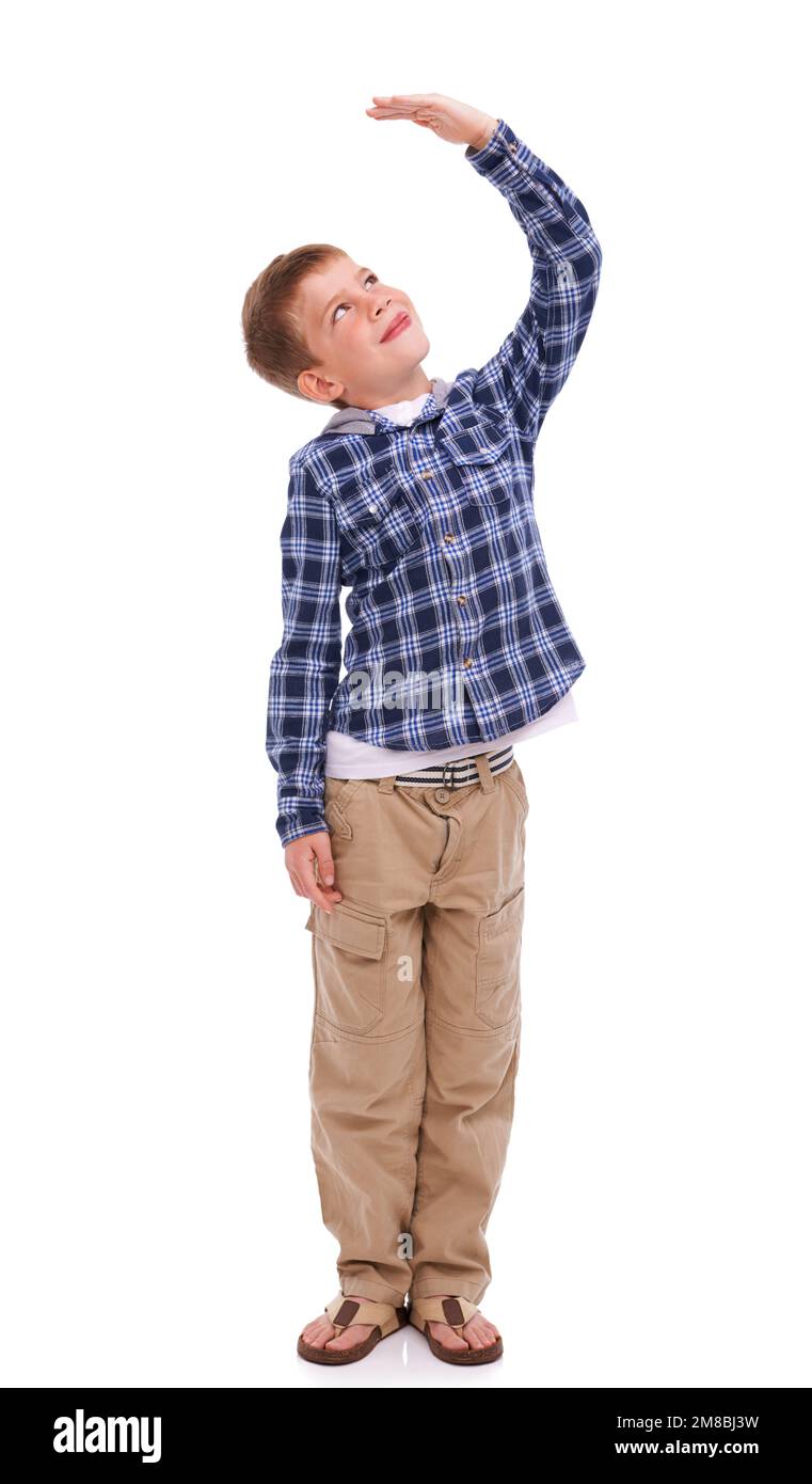 Children, growth and mockup with a boy measuring his height in studio isolated on a white background. Kids, hand and wall with a male child growing up Stock Photo
