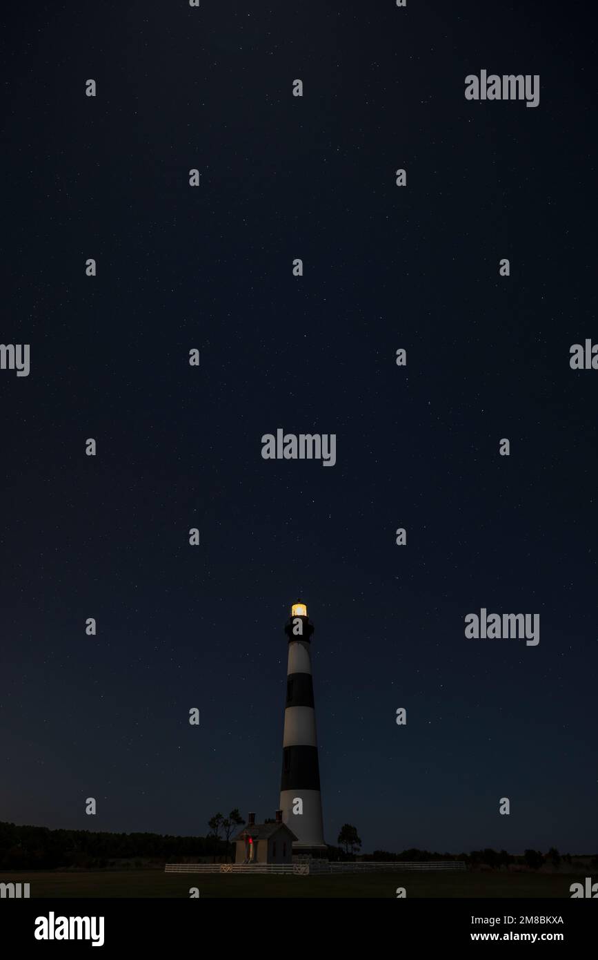 Bodie Island Lighthouse under stars and waxing gibbous moon in Cape