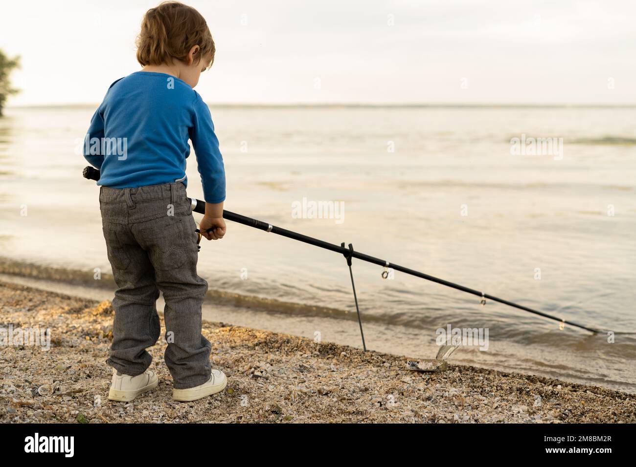 Adorable baby boy on river with fishing-rod and fishing. little child fishing on lake. baby in nature Stock Photo