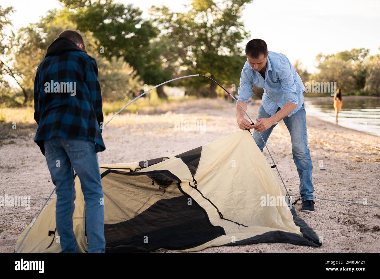 Father and son installing tent near the lake.Trekking and travel with kids concept image Stock Photo