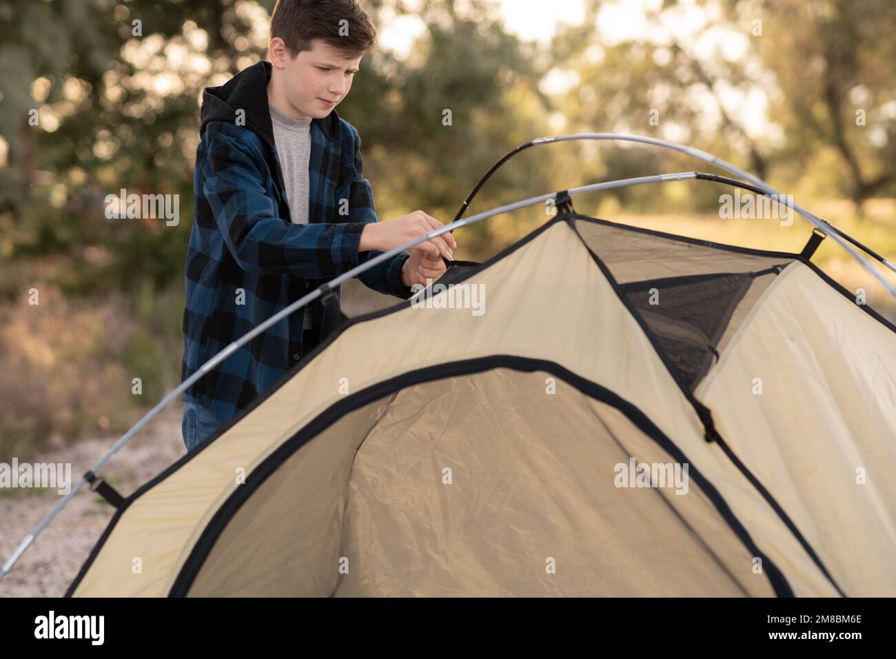 Camping people outdoor summer lifestyle tourists. boy installing tent. Natural children education Stock Photo
