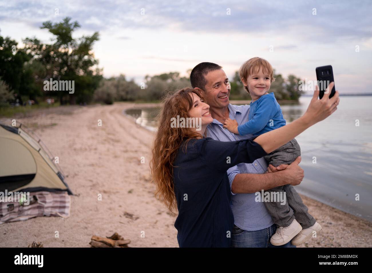 Portrait of Caucasian family with father, mother and little son selfie ...
