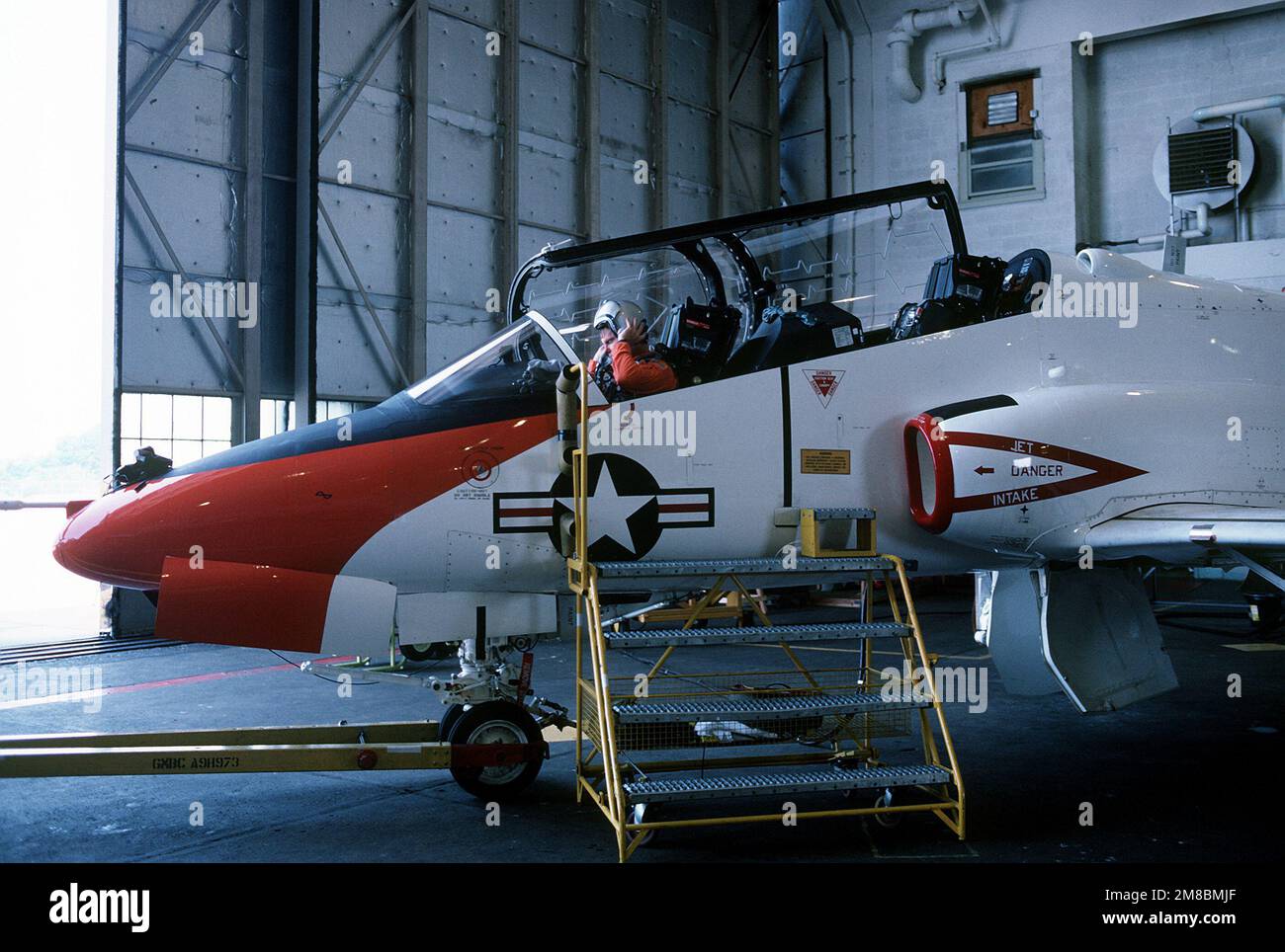 A test pilot dons his helmet before his T-45A Goshawk aircraft is towed ...