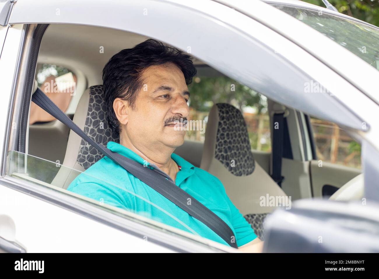 Happy mature indian man driving car in the city, Domestic life. People and Safety Concept. Stock Photo