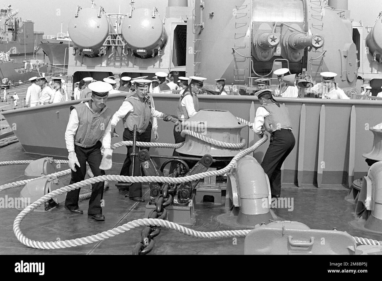 Soviet sailors wind a line around a capstan near the bow of the Slava