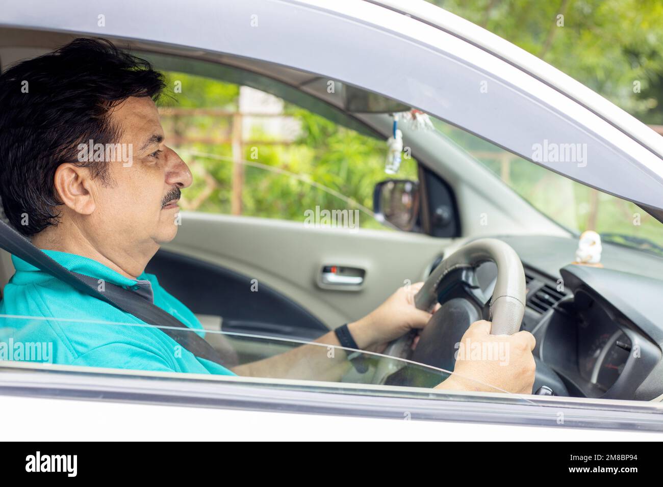 Happy mature indian man driving car in the city, Domestic life. People and Safety Concept. Stock Photo