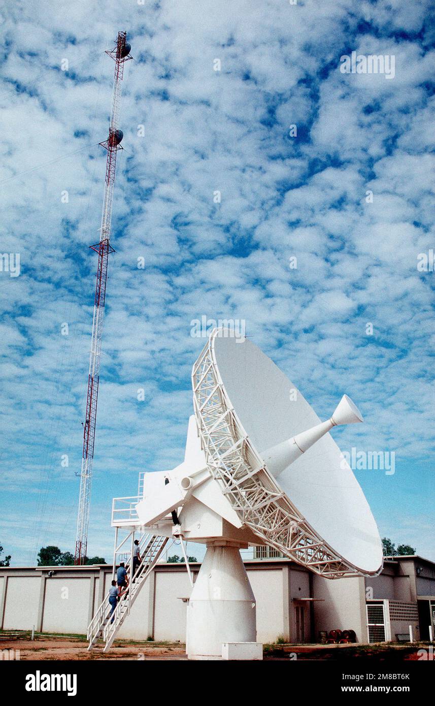Station personnel ascend a ladder leading to one of the satellite