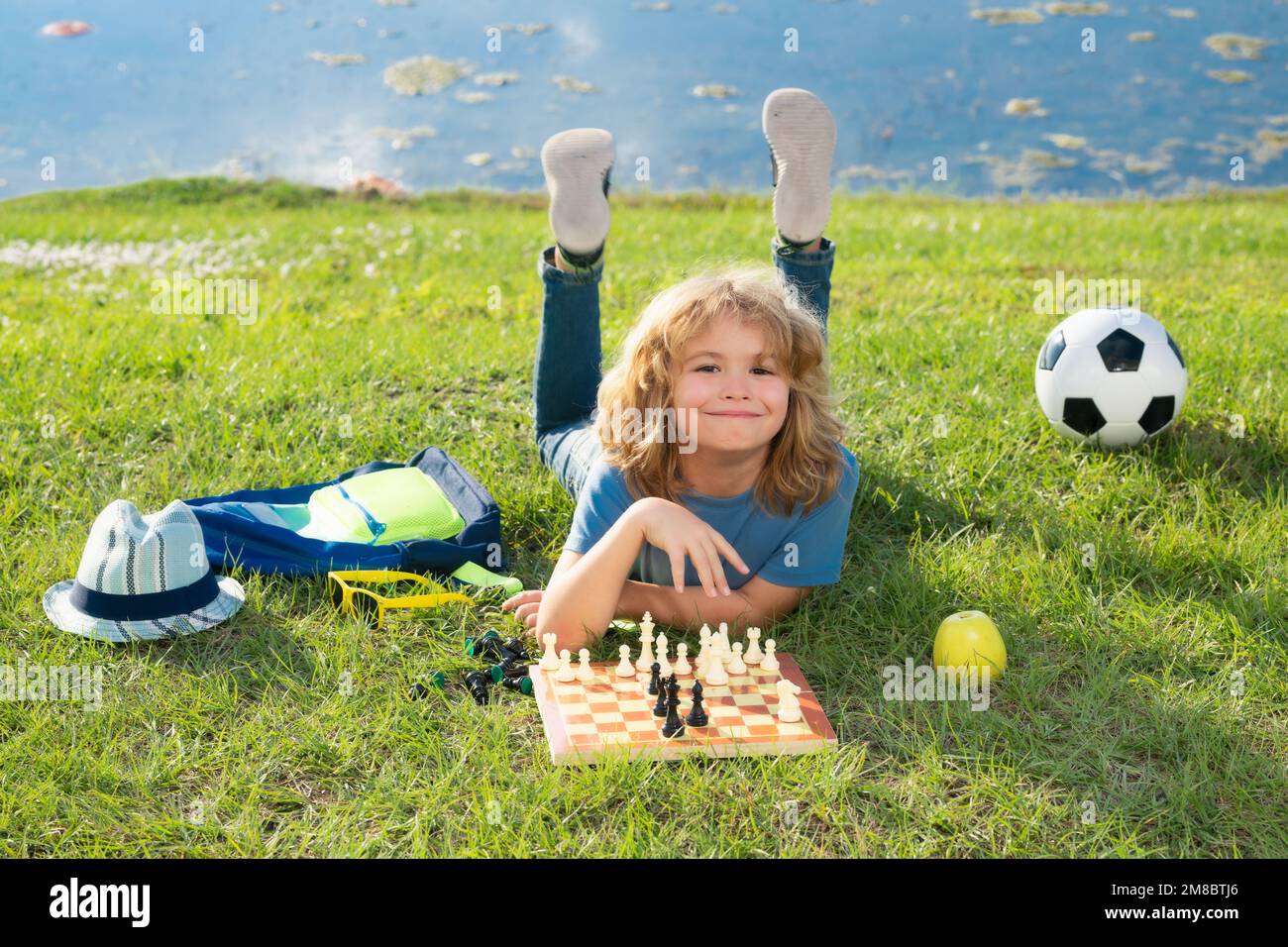 Chess game for kids. Child playing chess outdoor in park Stock Photo